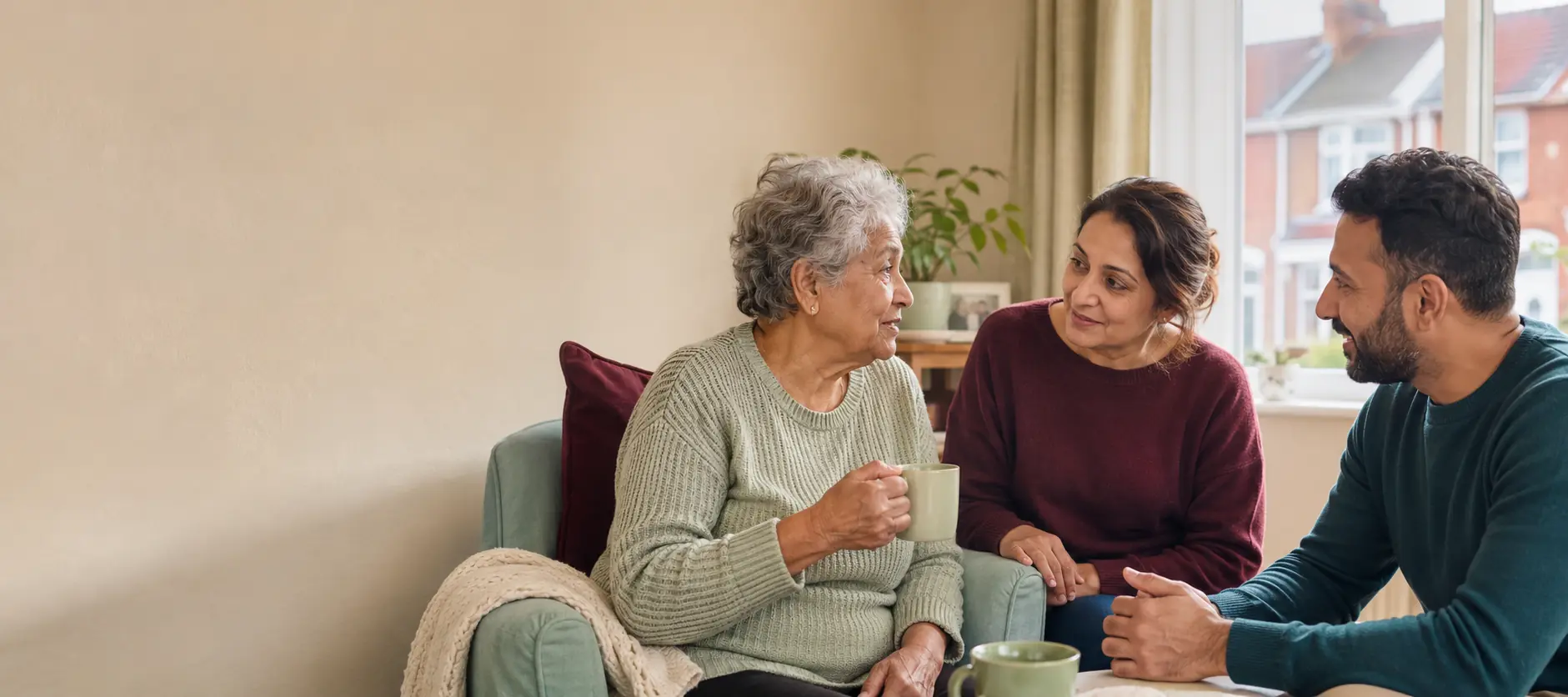 An older woman enjoying a relaxed conversation with two care professionals at home