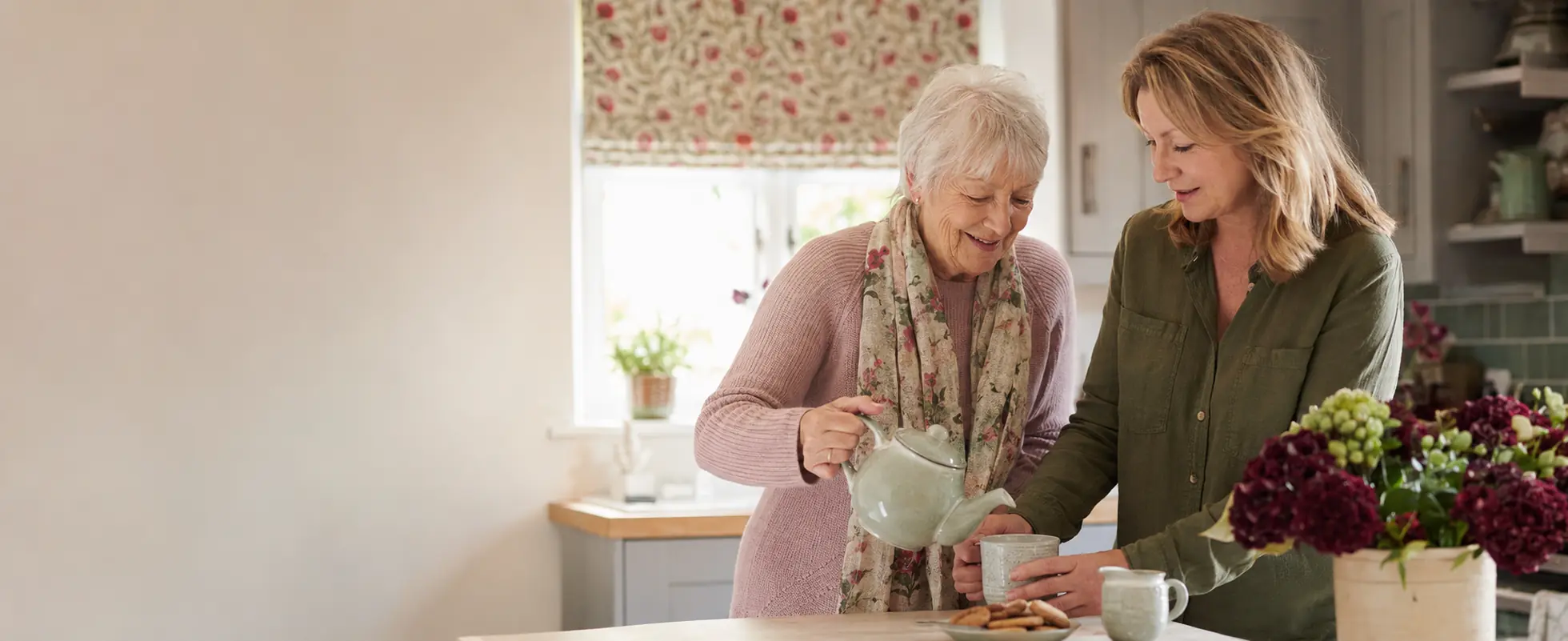 A woman and her care worker preparing tea together at home